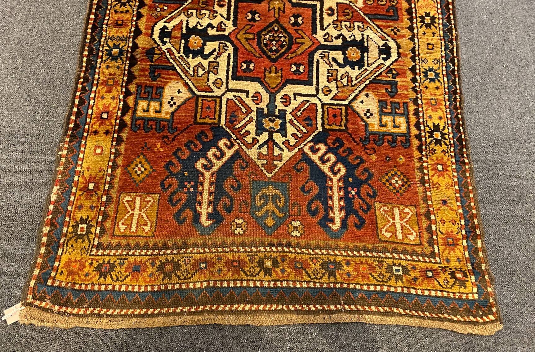 A Kazak red ground rug, 240 x 108cm